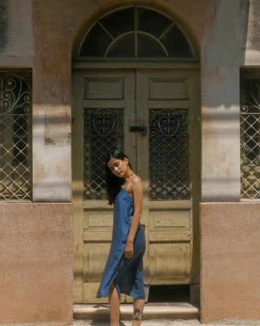 mujer de vestido azul en frente de  fachada antigua edificio merida