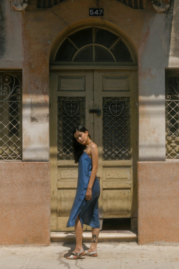 mujer de vestido azul en frente de  fachada antigua edificio merida